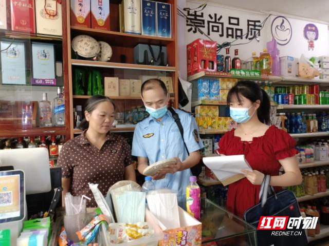 监督管理所执法人员在郴州市第九中学门口经营食品店的食品进行检查
